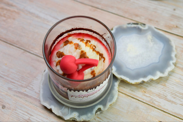 Mocha Frappuccino Candle - Candle with a red tool-shaped wick trimmer on a wooden surface